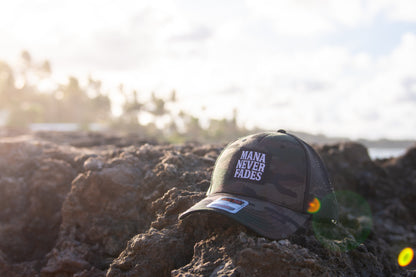 Black cap with 'Mana Never Fades' text on a field background